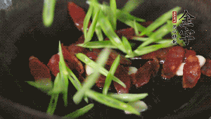 先后下香腸片、四季豆絲均勻翻炒，加適量清水燜煮一下。