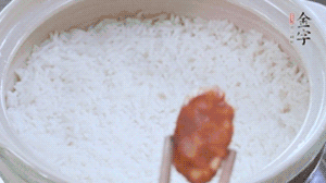 煮開后轉小火，當米飯出現(xiàn)小孔時，鋪上金字麻辣香腸。
