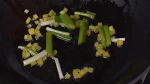 鍋中熱油，依次下姜粒、蔥段、蘆筍炒香。