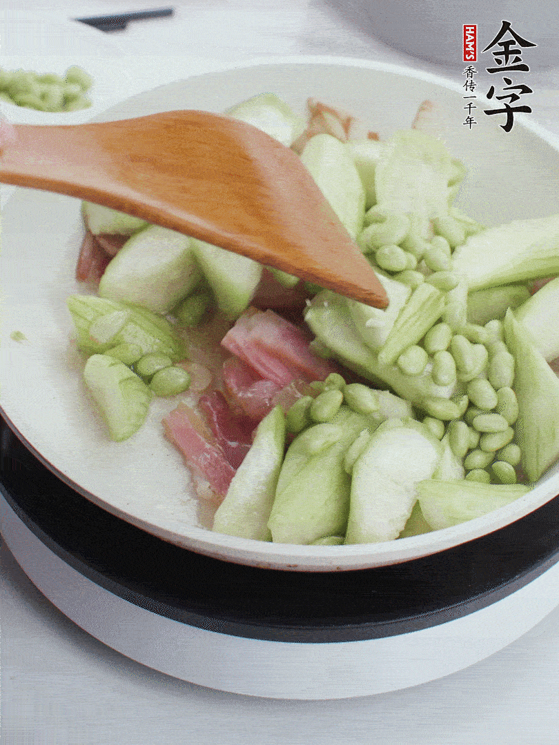 依次下絲瓜、青豆翻炒，炒至絲瓜打蔫縮小。