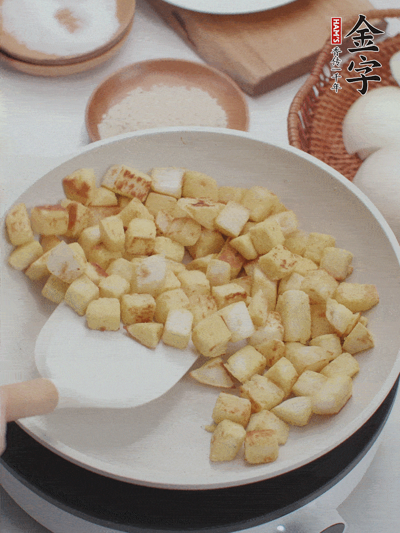 起鍋熱油，倒入饅頭丁，小火煎至蛋液凝固定型再翻面，饅頭丁部煎至金黃時盛起待用。
