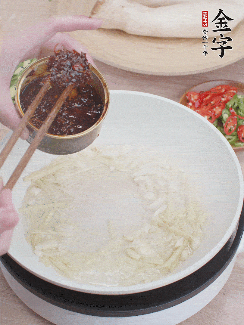 起鍋熱油，姜蒜、金字火腿干貝醬煸香。