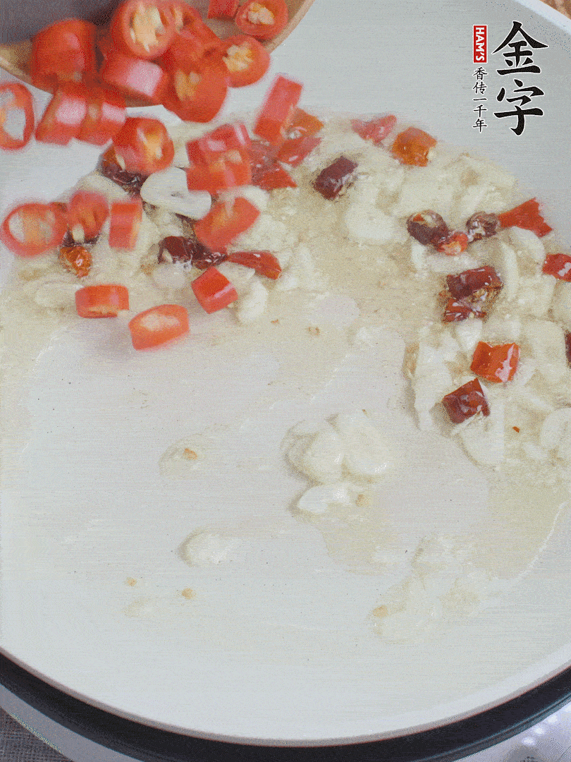 油6成熱，下蒜末、干紅辣椒煸炒，出香味后再放美人椒、香腸。