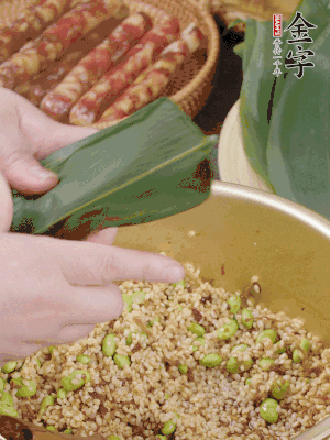 粽葉往下折，完全蓋住，兩側(cè)捏緊。