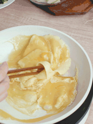 油6成熱時(shí)，下雞蛋液，邊緣凝固時(shí)翻拌成塊狀。