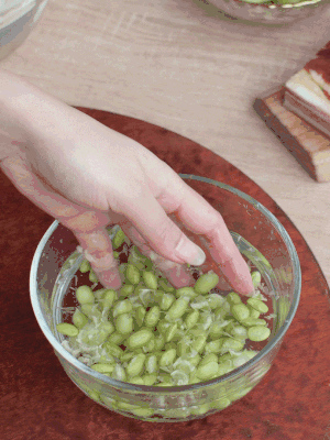 青豆剝殼，搓去外衣。