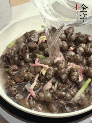 倒處理干凈的螺螄翻炒，加3勺料酒。加清水蓋過螺螄，中火蓋蓋煮5分鐘。