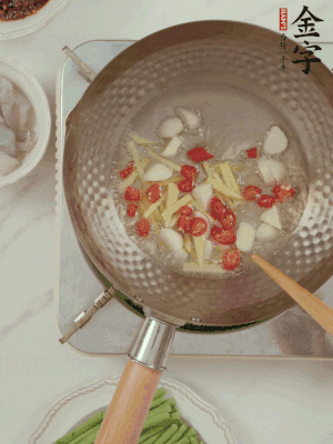 油7成熱時，下大蒜粒、姜絲、小米辣煸香。