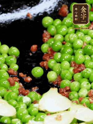 鍋內(nèi)少許油，下火腿煸香，再下甜豆米、百合翻炒，少許鹽、一點水煮到收干