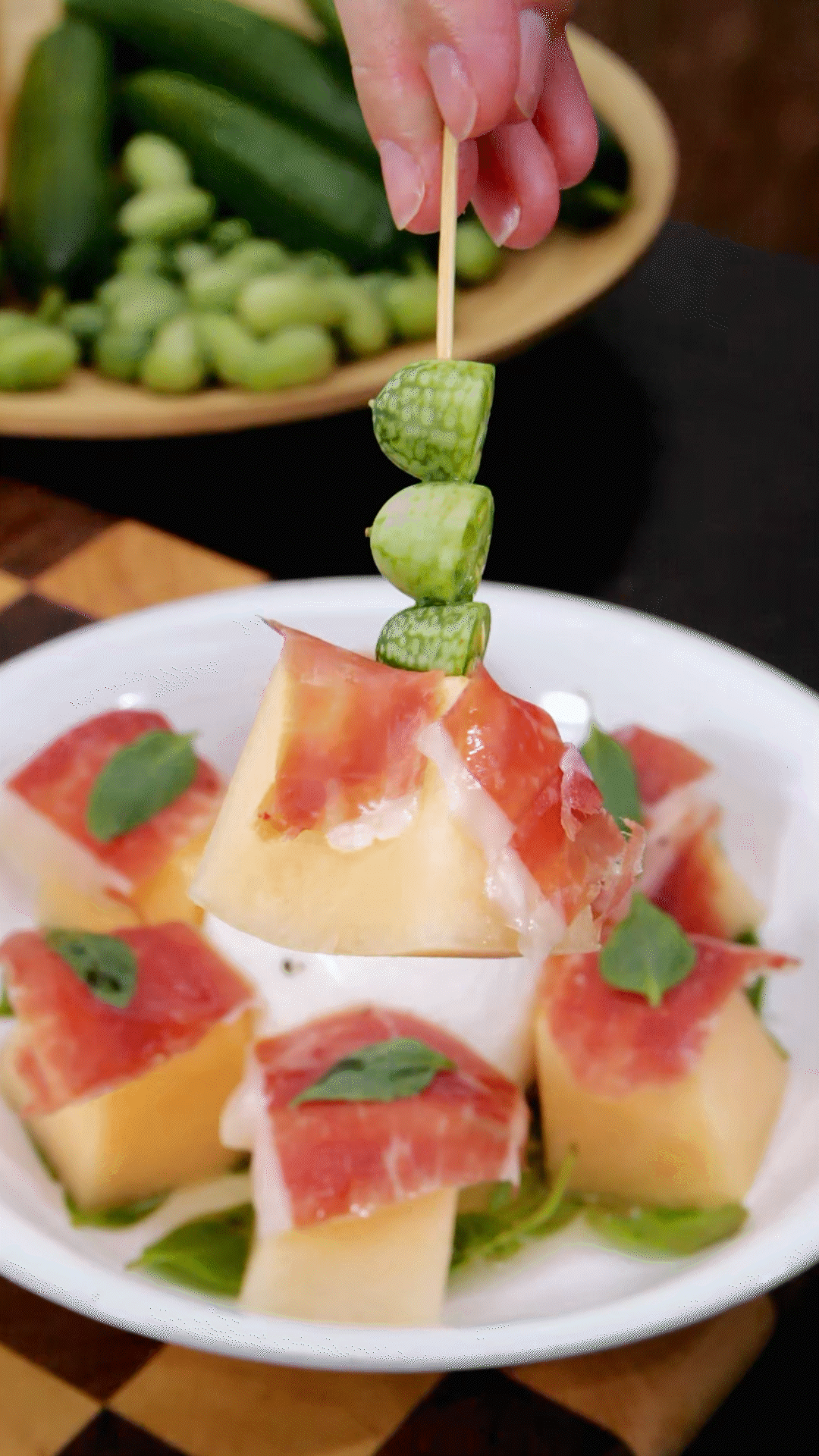 依次放上：布拉塔奶酪球、密瓜和巴瑪火腿